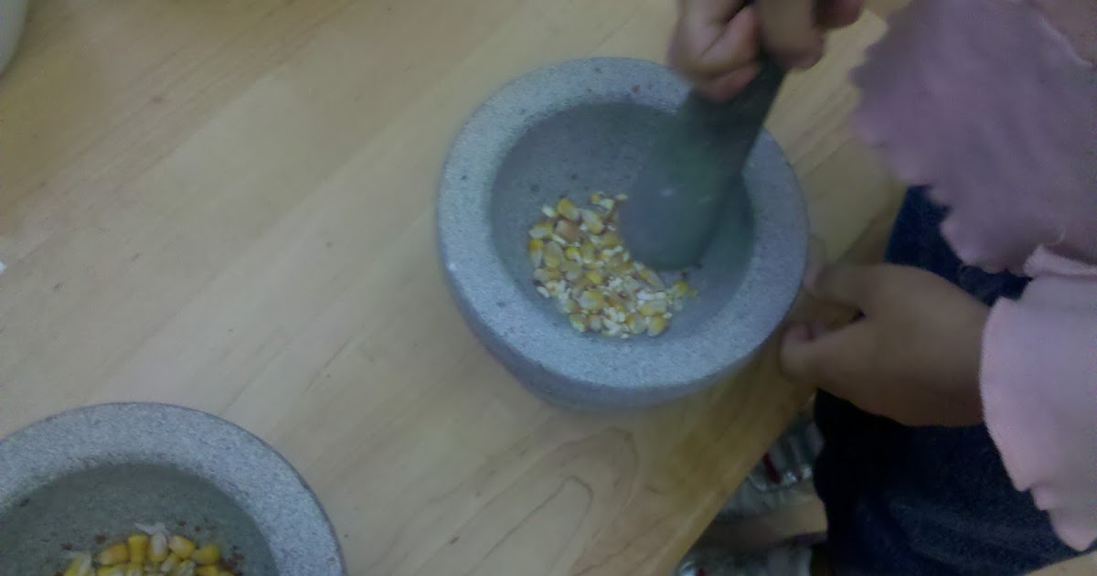little preschool on the prairie grinding corn with the mortar and pestles