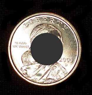 A Sacajawea dollar coin with a hole in the middle.