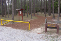 Through the gate and then follow the path to the right to get to the trail head.