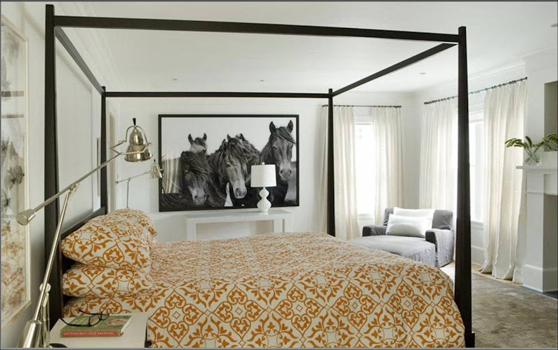 A wood four poster canopy bed makes a statement in the center of 