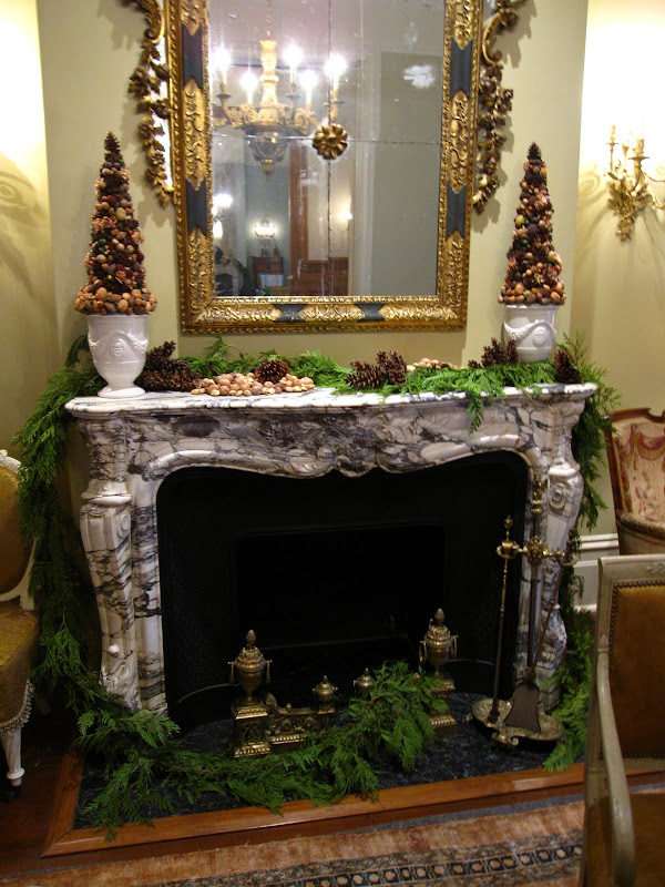 Fireplace in the men's parlor of a historic New Orleans mansion with a garland made of fresh pine, pine cones and nuts