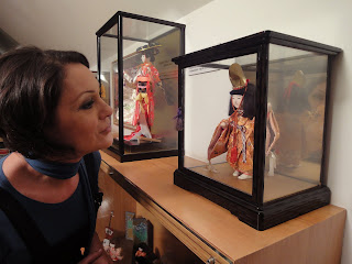 Fotografia de Cristina Silva a observar uma boneca japonesa
