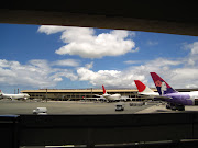 This is a picture through a part in the airport of the pretty airplanes. (img )
