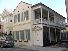 A typical Charleston home with earthquake rods, a single door to the side porches and a garden.