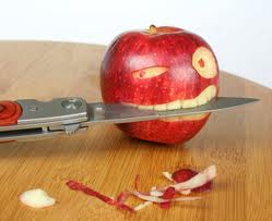 Apple waaruit een knipogende smiley is gesneden. De smiley houdt een mes tussen zijn tanden.