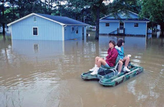 Mujeres en un bote en el vecindario residencial, inundado, de Tupelo, Mississipi