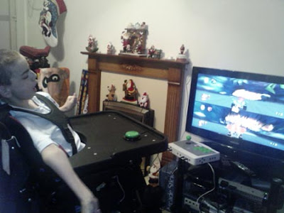 Colin playing Crash Bandicoot (I think) racing game on his PS2 using accessibility switches and his C-SID.