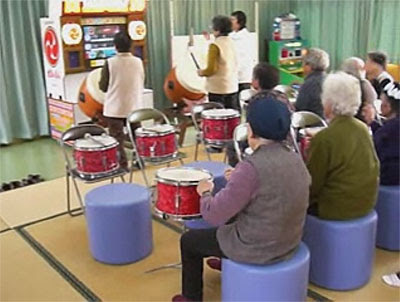 Namco Rehabilitainment Glimpses - Image of a group of elderly Japanese people playing drums alongside a Taiko Drummer video game