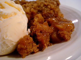 apple pudding cake and a scoop of vanilla ice cream on a white plate