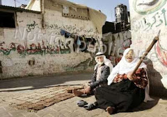 Palestinian refugees sit at Khan Younis refugee camp