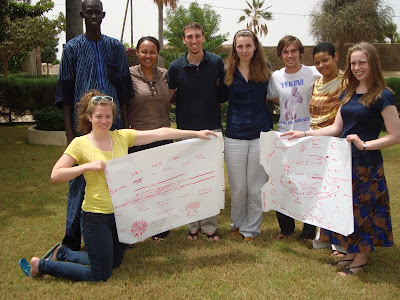 Malick Niang (à gauche), assistant au département des programmes de Tostan au Sénégal, et Zoe Williams (debout, à gauche), coordinatrice des bénévoles de Tostan, en compagnie des nouveaux bénévoles à Thiès.