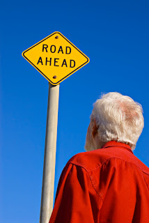 a man standing next to a road sign