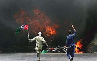 Supporters of Pakistan Peoples party are seen after setting a vehicle on fire