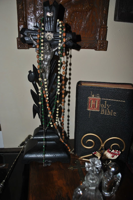 A Black Forest crucifix adorned with antique rosaries