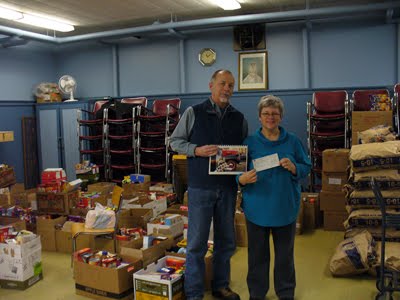 LOCAL PHOTOGRAPHER HANDS OVER A CHEQUE TO THE FOOD BANK