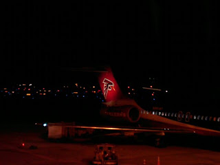 a plane at night with lights in the background