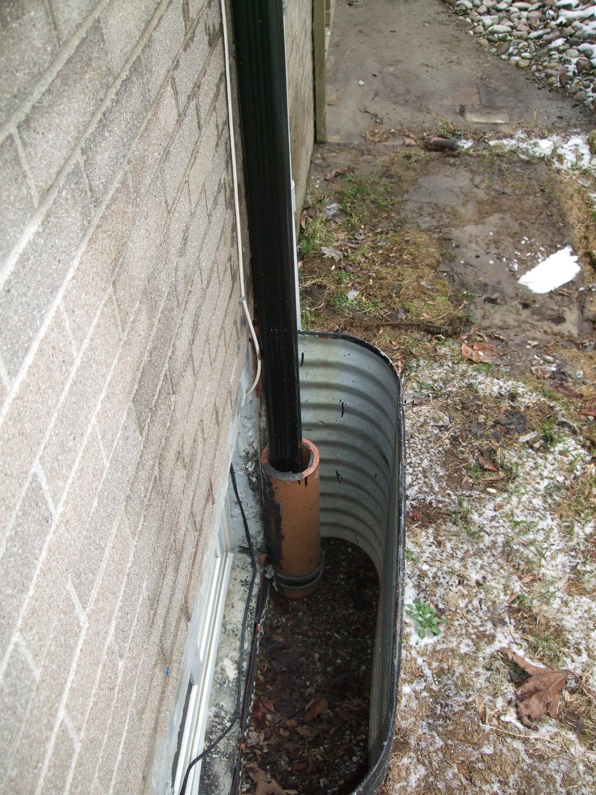 Downpipe goes into clay pipe in basement window well