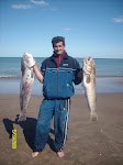 GUSTAVO MODELANDO EN LA PLAYA CON DOS SALMONES