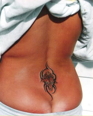 Tribal design and tiger head tattoo on lower back.