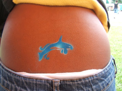 Blue small dolphin lower back tattoo.