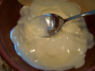 Vegan White Chocolate in brown bowl being stirred with spoon