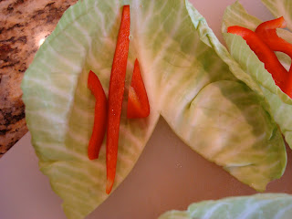 Cabbage leaf cut into v shape with slices of red bell pepper