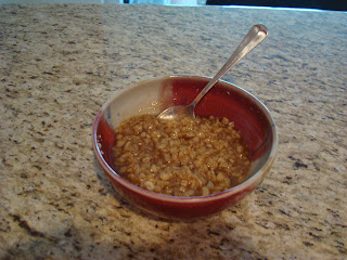 Finished oats in bowl toped with cinnamon and agave with spoon