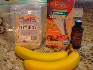 Xanthum gum, almond milk, vanilla and bananas on countertop