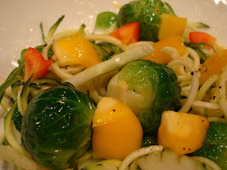 Close up of Zuke Noodles tossed with mixed vegetables white bowl