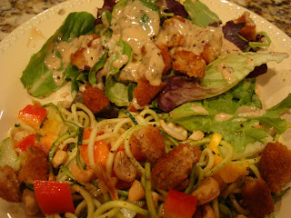 Zucchini noodles with vegetables and peanut sauce alongside salad with soy nuggets 