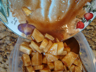 Pouring apple mixture over crust in clear container 