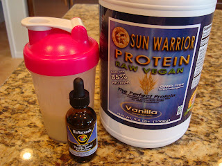 Sun Warrior Vanilla Protein Powder in container, NuNaturals Stevia and shaker bottle with ingredients mixed together in water
