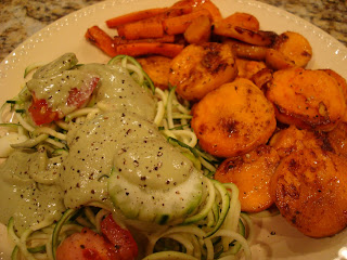 Roasted Sweet Potatoes and Carrots in foil lined pan with glaze on plate with zucchini noodles and Goddess Salad Dressing