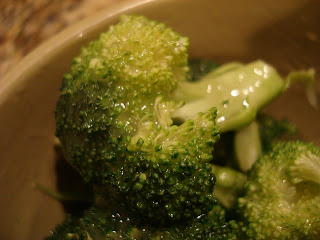 Up close of glazed broccoli in brown bowl