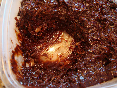Raw Vegan Chocolate Coconut Snowballs in container with scoop taken out