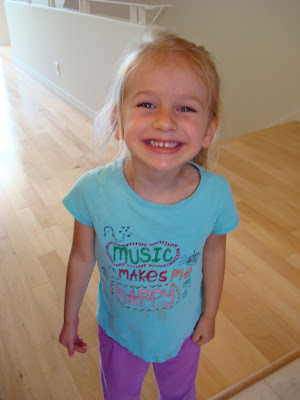 Young girl smiling in blue shirt and purple pants