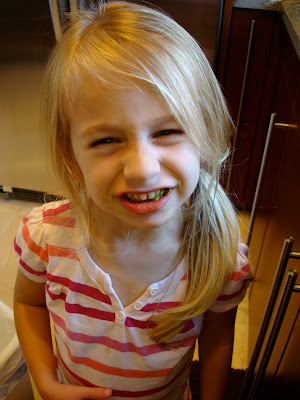 Young girl with ponytail smiling in kitchen