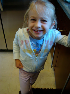 Young girl with hand on countertop smiling