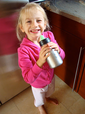 Young girl standing drinking from re-useable bottle 