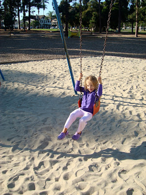 Young girl swinging on swing
