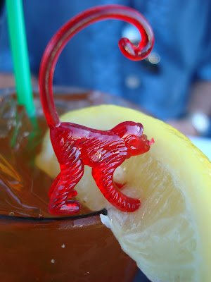 Red plastic monkey licking lemon slice 