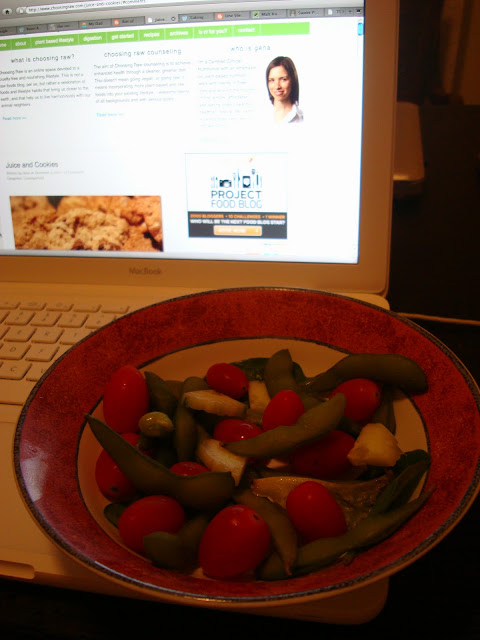 Bowl of vegetables next to open laptop