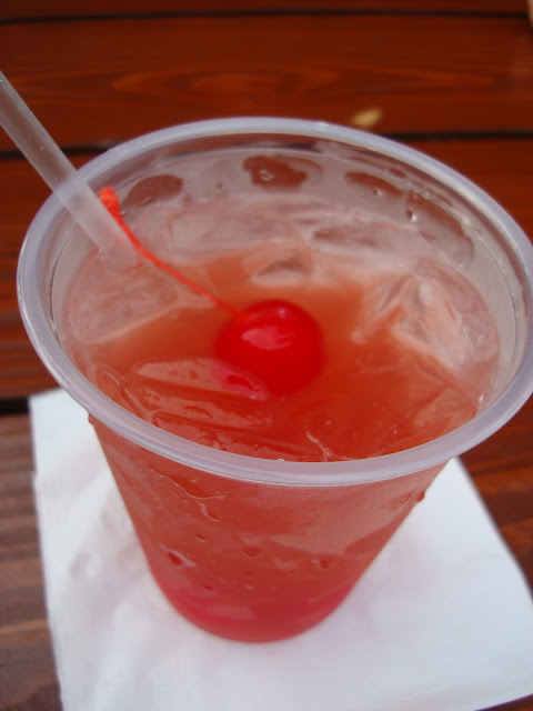 Sex on the Beach cocktail with cherry in plastic cup