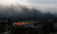 Photo from Guardian.co.uk: ires rage in central Cairo following clashes between protesters and police, as President Mubarak ordered a military curfew. Photograph: Yannis Behrakis/Reuters