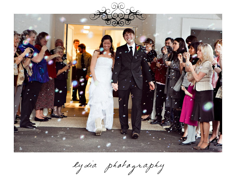 Bride and groom getting a bubble exit at snowy, green and orange wedding in Shingletown, California