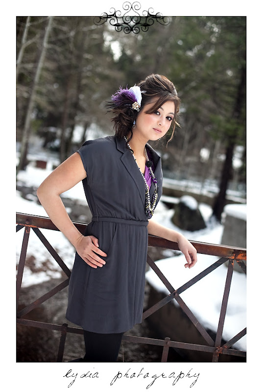 Devi wearing a purple hair piece and necklace standing in front of a river