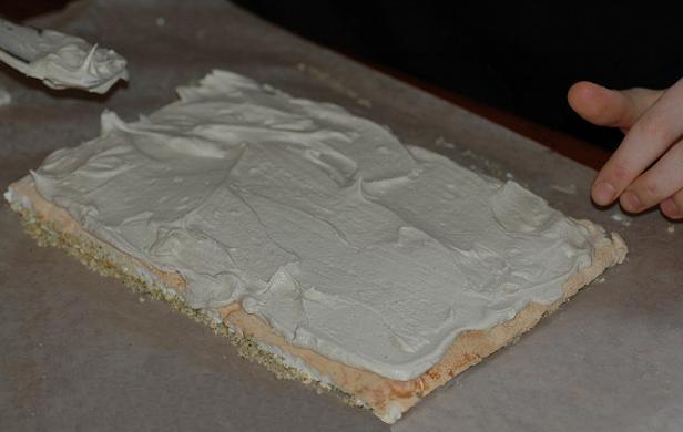 Spreading the wattleseed cream on the meringue base Spreading the wattleseed cream on the meringue base