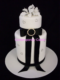 Extended tier base cake with sugar lilies and diamonte hearts.
