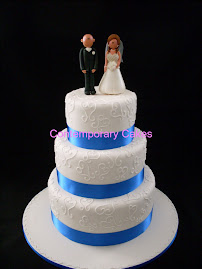 3tier round stacked cake with piped open loop herats with personalised figurines.