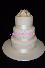 3 tier round stacked cake with a quilted effect middle tier cake with ivory sugar roses.